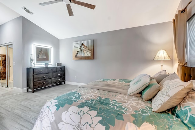 bedroom featuring vaulted ceiling, light hardwood / wood-style flooring, ceiling fan, and a closet