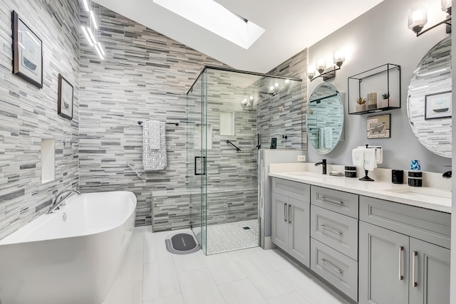 bathroom with vanity, shower with separate bathtub, tile patterned floors, and a skylight