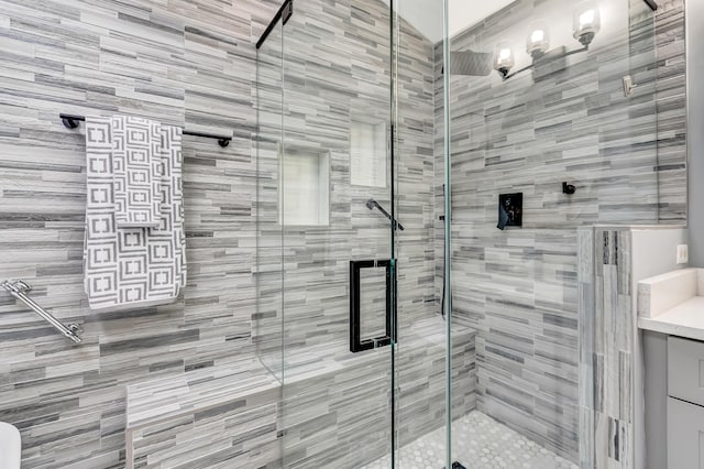 bathroom featuring vanity and a shower with shower door