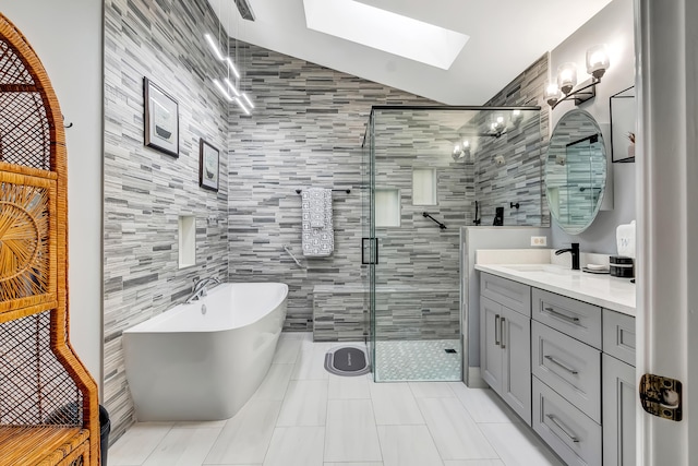 bathroom with vanity, a skylight, tile patterned floors, and independent shower and bath