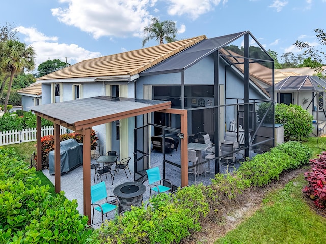 rear view of house with a patio, a lanai, and a fire pit