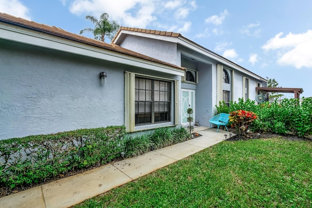 doorway to property with a yard