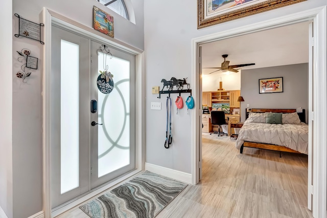 foyer entrance with ceiling fan, plenty of natural light, and light wood-type flooring