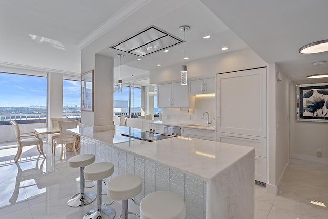 kitchen featuring plenty of natural light, a sink, black electric cooktop, and white cabinets