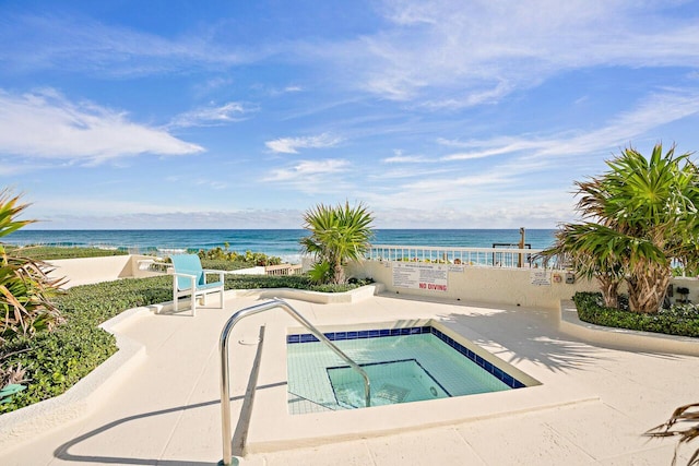 view of pool with a patio, a beach view, and a water view