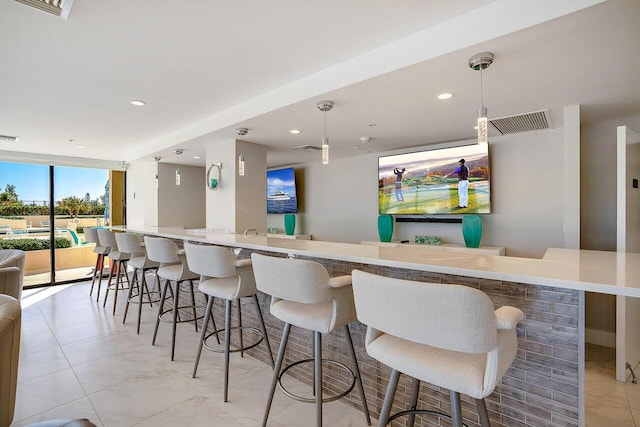 bar featuring pendant lighting and a wall of windows