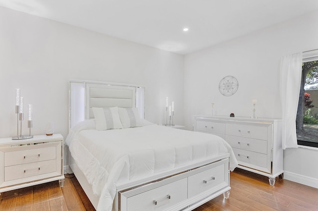 bedroom featuring baseboards, wood finished floors, and recessed lighting