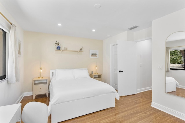 bedroom featuring light wood finished floors, baseboards, visible vents, and recessed lighting