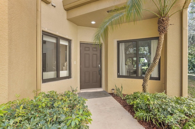 view of exterior entry featuring visible vents and stucco siding