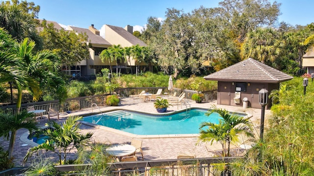 community pool featuring a patio area and fence