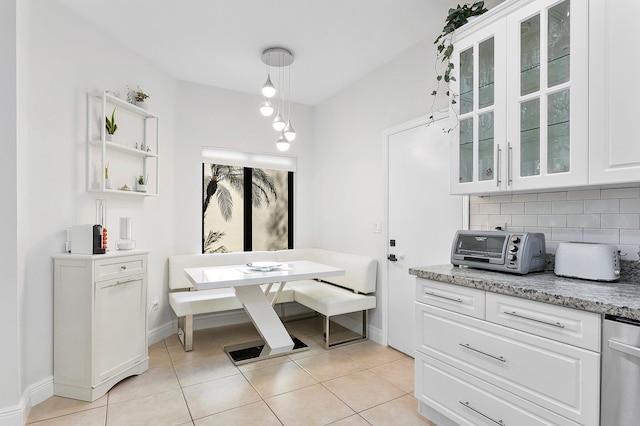 bathroom featuring baseboards, tile patterned flooring, and decorative backsplash