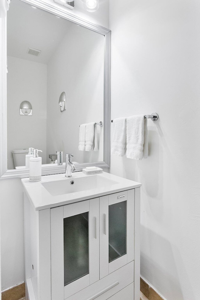 bathroom featuring visible vents, vanity, and toilet