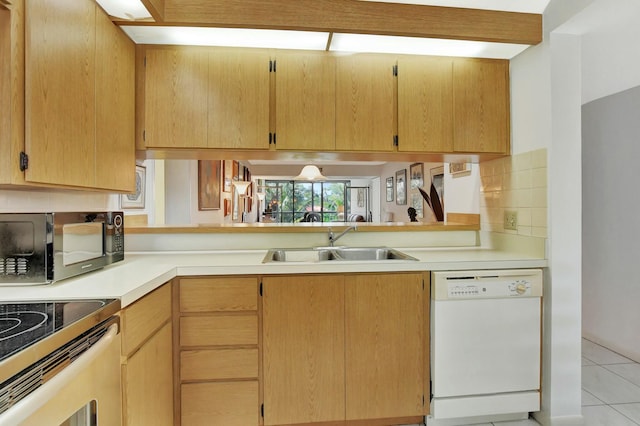 kitchen with sink, white dishwasher, tasteful backsplash, light tile patterned flooring, and light brown cabinets