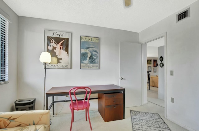 home office featuring light carpet and a textured ceiling