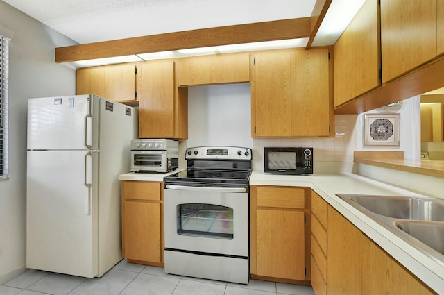 kitchen featuring light tile patterned flooring, sink, tasteful backsplash, white fridge, and electric stove