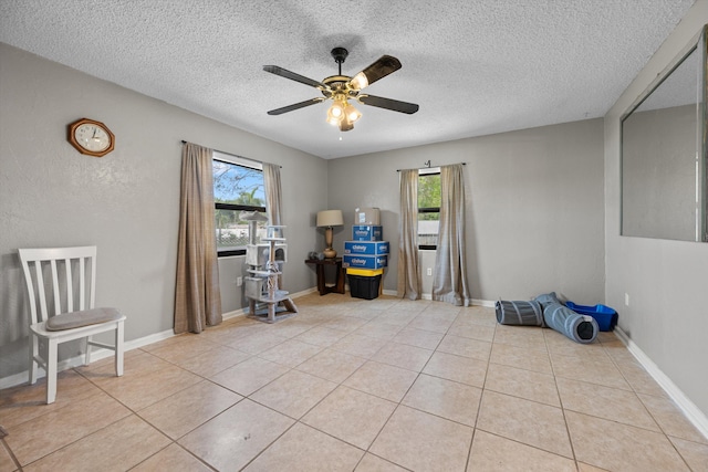 interior space featuring ceiling fan, a wealth of natural light, and light tile patterned floors