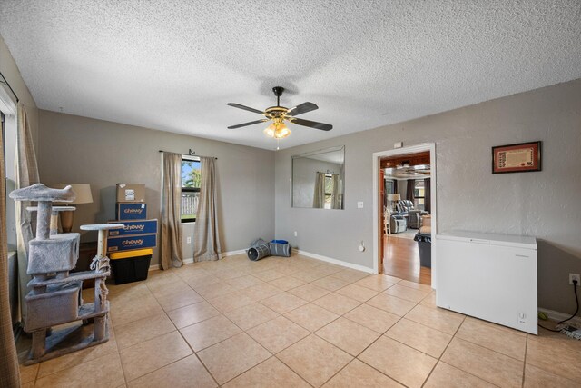 miscellaneous room featuring light tile patterned flooring, a textured ceiling, and ceiling fan