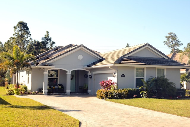 single story home with a garage and a front lawn