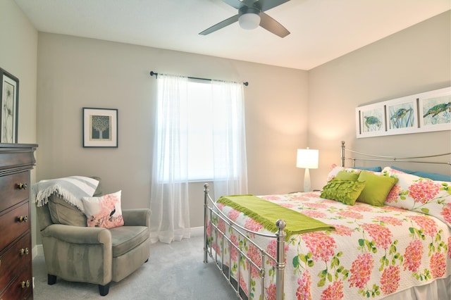 carpeted bedroom featuring ceiling fan and multiple windows