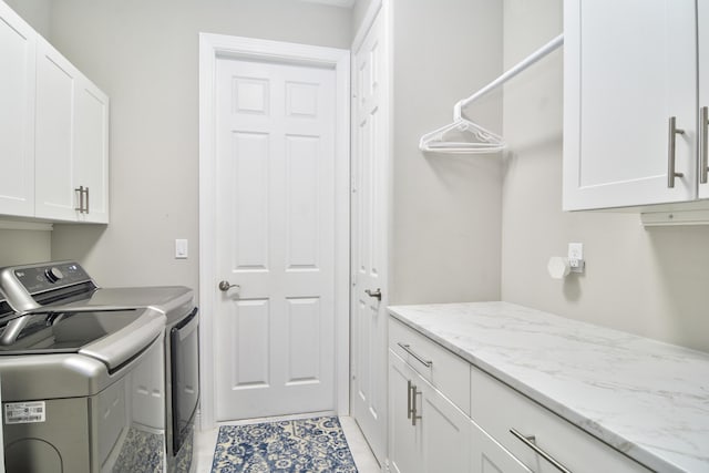 washroom with washer and dryer and cabinets