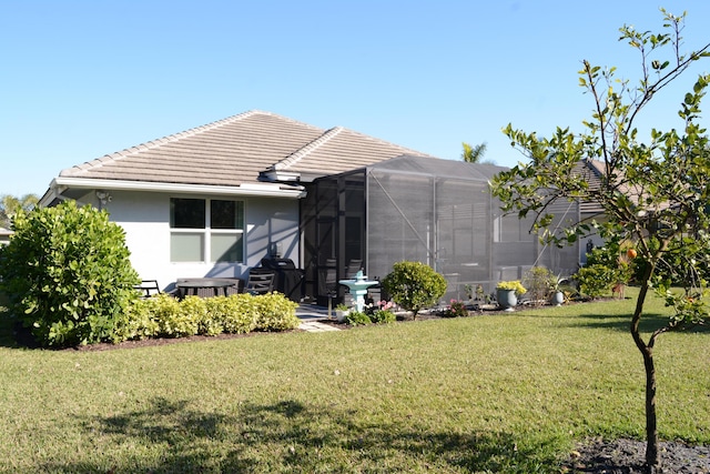 back of house with a lanai and a yard