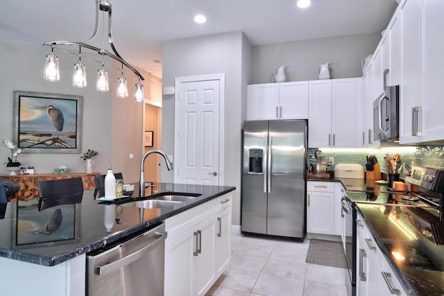 kitchen with white cabinetry, an island with sink, stainless steel appliances, and sink