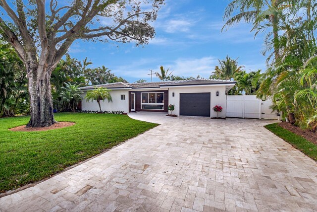 rear view of property with a yard and a garage