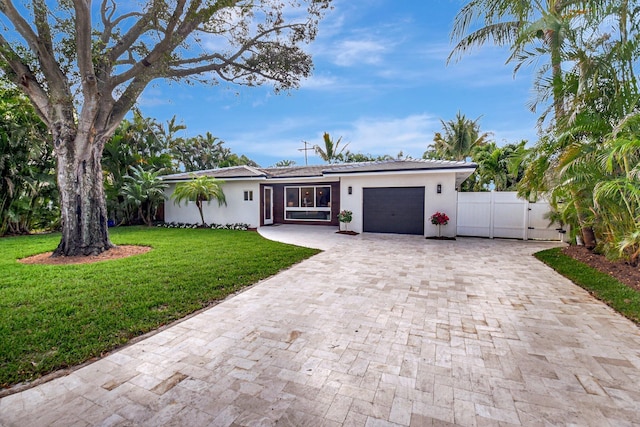 ranch-style home featuring a garage and a front lawn