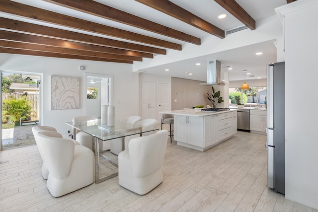 dining area with light hardwood / wood-style floors and beam ceiling