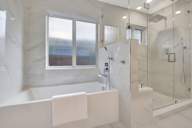 bathroom featuring shower with separate bathtub