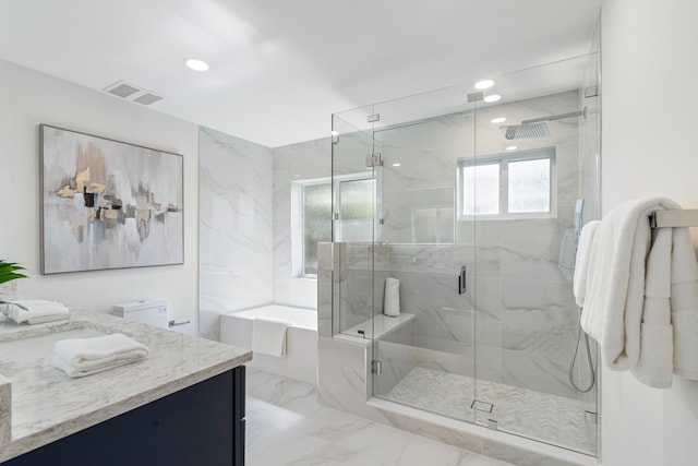 bathroom featuring vanity and independent shower and bath