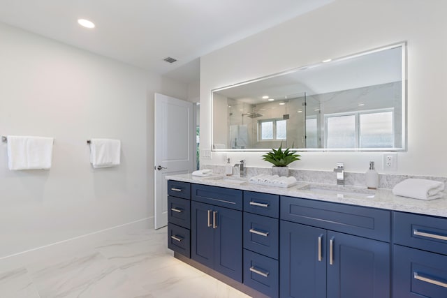 bathroom with a shower with shower door and vanity