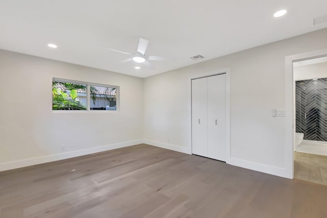 unfurnished bedroom with a closet, hardwood / wood-style flooring, and ceiling fan