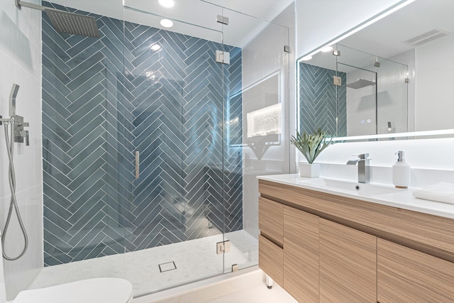 bathroom with vanity, an enclosed shower, and toilet