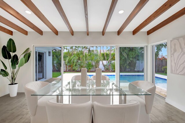 kitchen featuring appliances with stainless steel finishes, hanging light fixtures, white cabinets, kitchen peninsula, and beamed ceiling