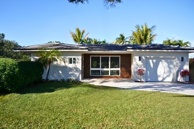 view of front of house featuring a front lawn and a garage