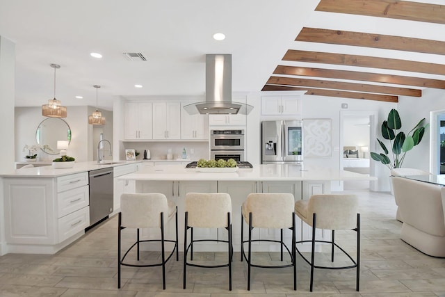 kitchen featuring sink, white cabinetry, island range hood, decorative light fixtures, and stainless steel appliances