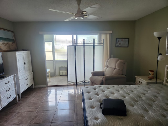 bedroom with tile patterned flooring, a textured ceiling, and ceiling fan