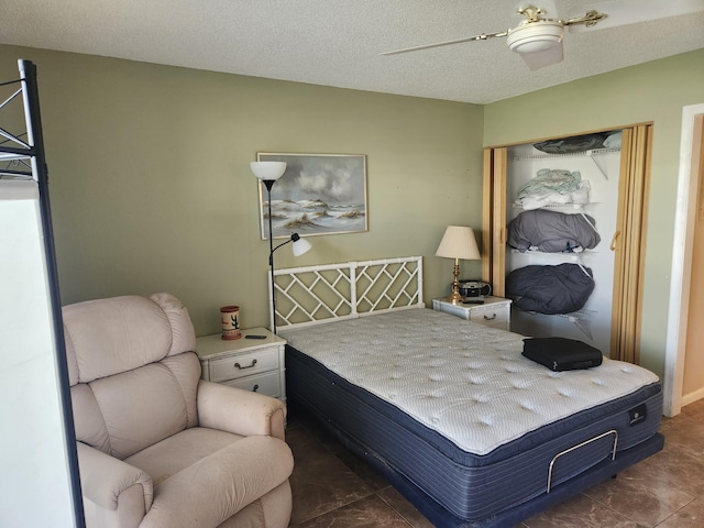 bedroom featuring dark tile patterned floors, a textured ceiling, and ceiling fan