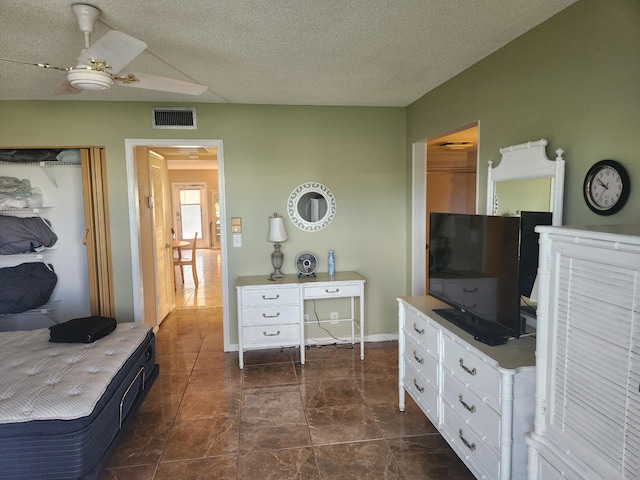 bedroom with a textured ceiling and ceiling fan