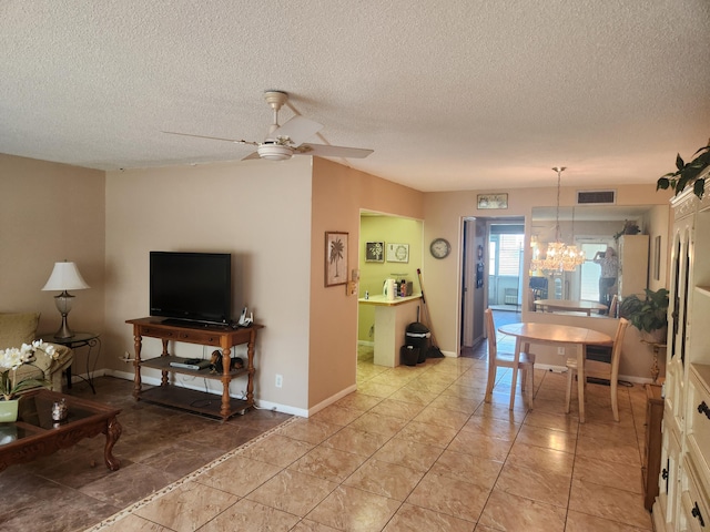 interior space featuring ceiling fan with notable chandelier, a textured ceiling, visible vents, and baseboards