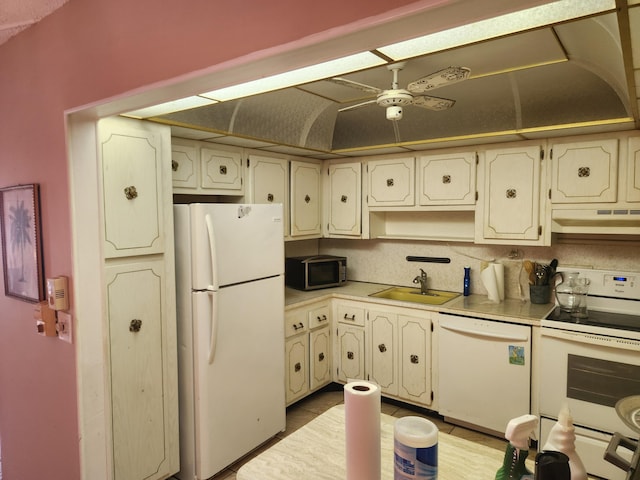 kitchen with light tile patterned flooring, sink, white appliances, vaulted ceiling, and ceiling fan