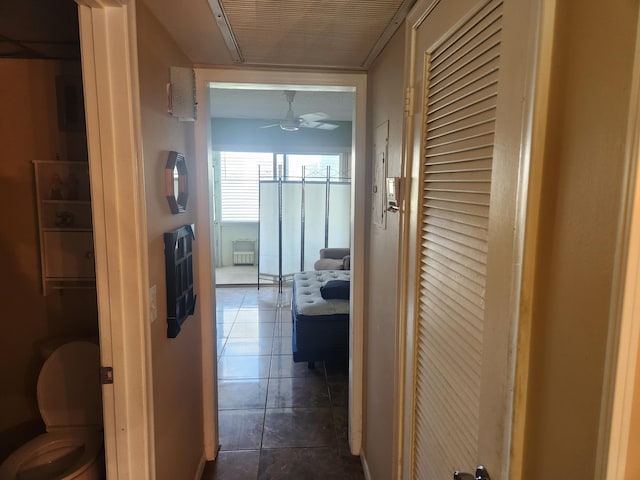 hall with dark tile patterned flooring and radiator heating unit