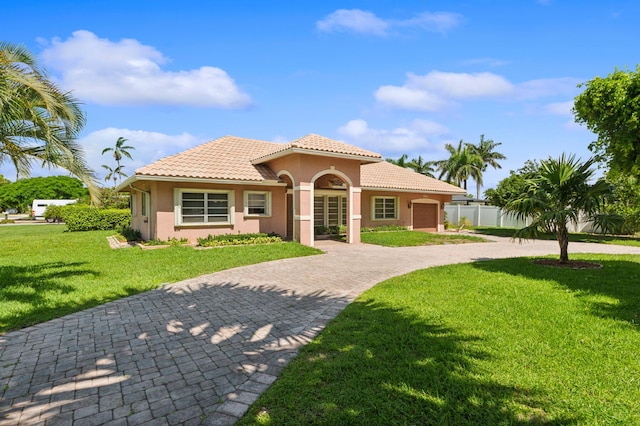 mediterranean / spanish-style home with a garage and a front yard