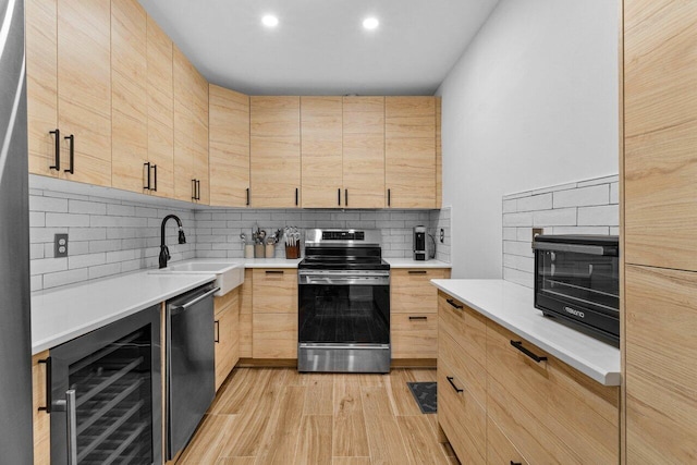 kitchen featuring wine cooler, appliances with stainless steel finishes, sink, and light brown cabinets