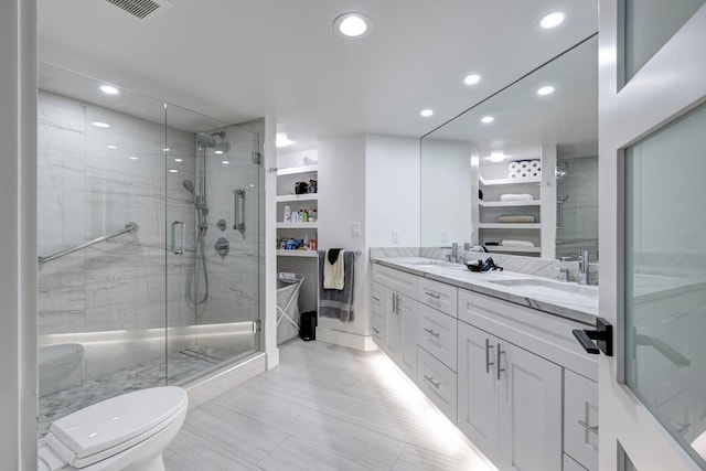 bathroom with vanity, a shower with shower door, and toilet