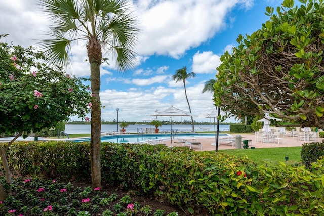 view of pool featuring a water view and a patio area