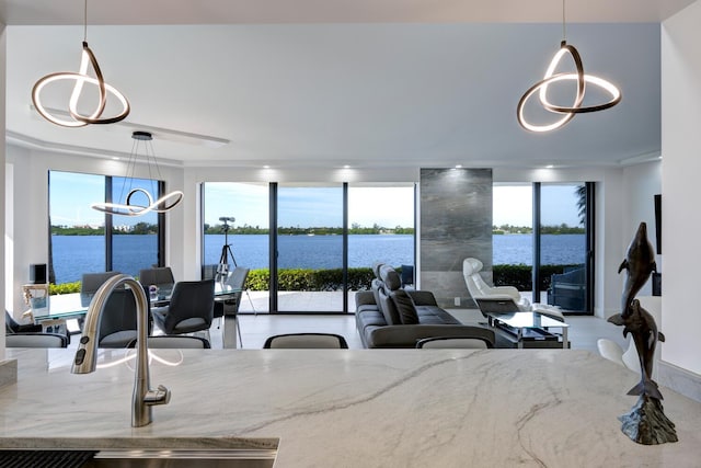 kitchen featuring a water view and hanging light fixtures