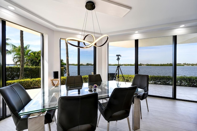 sunroom with a water view and a notable chandelier