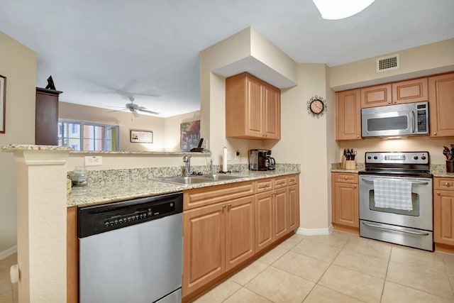 kitchen with sink, light tile patterned floors, ceiling fan, stainless steel appliances, and light stone countertops